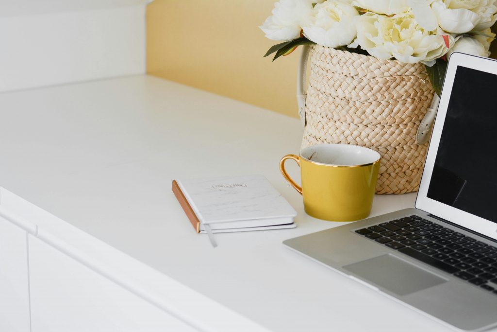 ordinateur, tasse de café, carnet et fleurs sur bureau (micro-entreprise)